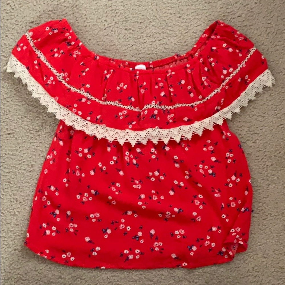 Red off the shoulder shirt with white flowers.